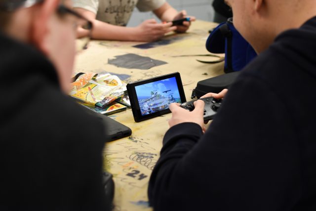 Game club members gather around a Nintendo Switch to play Super Smash Bros. Ultimate. Photo by Emma Brashear. 