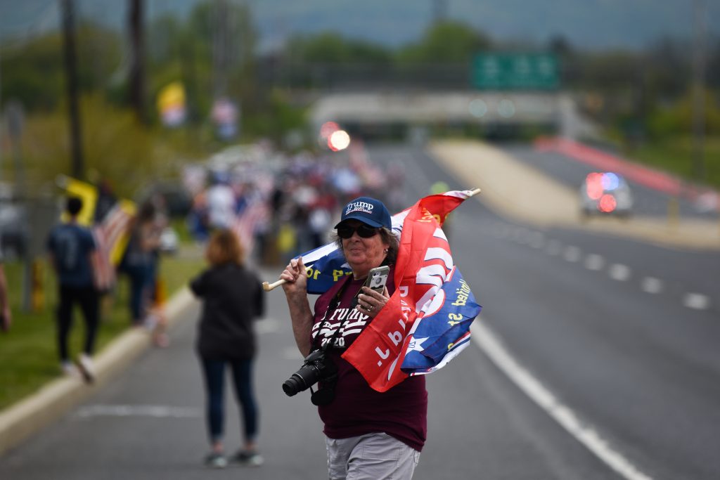 A woman crosses Route 100 to join the crowd of people waiting on the side of the road the president’s motorcade would arrive on later that afternoon. Photo by Emma Brashear.