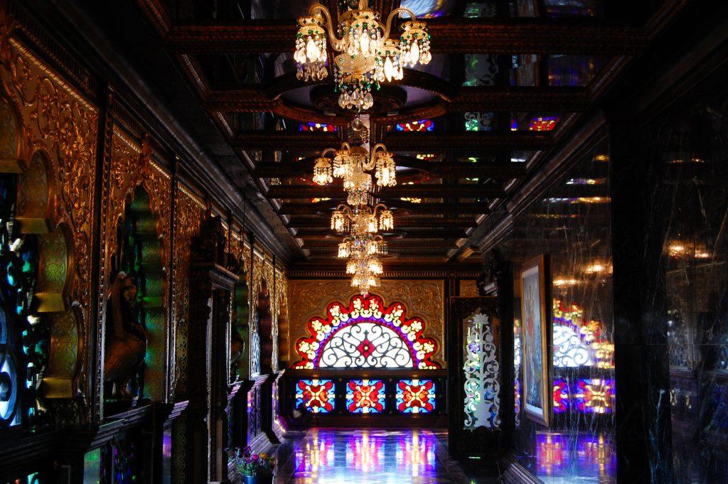 The inside of the Palace of Gold is relatively dark, although chandeliers across the ceiling help illuminate it, and sunlight spills in through the elaborate stained glass windows. Photo by Meliha Anthony.