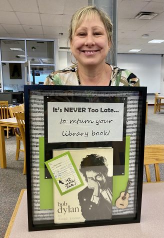 Librarian Kelly Bower poses with the returned book. Photo courtesy of Bower.
