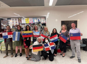 The language department teachers pose with flags representing their nationalities.
