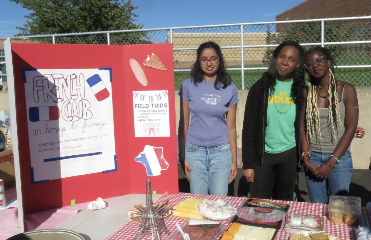 Pictured right to left: Micheal Akinyi, Ogonna Nnodimele, and Nelara Wijesuriya pose at 2023 Homecoming Tailgate at the French Club table. Photo by Emme Pechulis. 