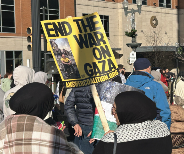 A protestor holds a sign proclaiming “End the war on Gaza” and a reference to the A.N.S.W.E.R. Coalition, an antiwar umbrella group. Over 1,500 pro-Palestinian protestors gathered on the corner of 7th Street and Hamilton Street in Allentown on Nov. 24 to pray and push for a ceasefire in the Gaza strip. Photo by Gavin Germain.