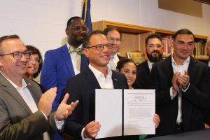 Gov. Josh Shapiro displays the signed education budget. Photo by Gabe Meyers.