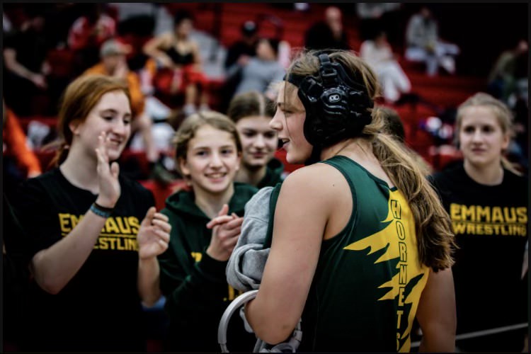 Junior Olivya Kroope celebrated with the girls wrestling team after winning a match. Photo courtesy of Kroope.